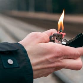 close up of hand holding lit candle